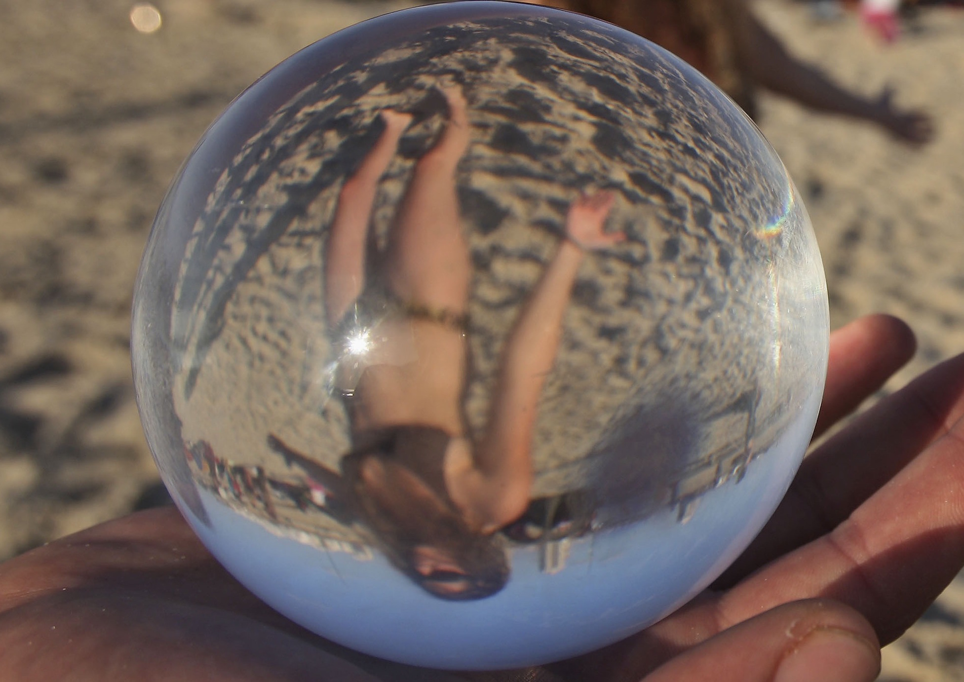An Israeli man holds a crystal ball as others perform on the beach of the Israeli coastal city of Netanya Friday, May 1, 2009. More than 100 people gathered at the event which was held to promote "Love and Peace", organizers said. (AP Photo/Muhammed Muheisen)